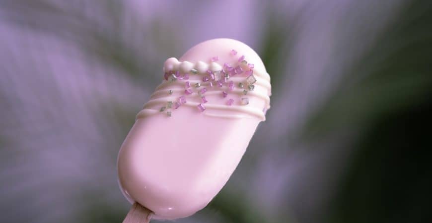 white heart shaped lollipop with pink sprinkles
